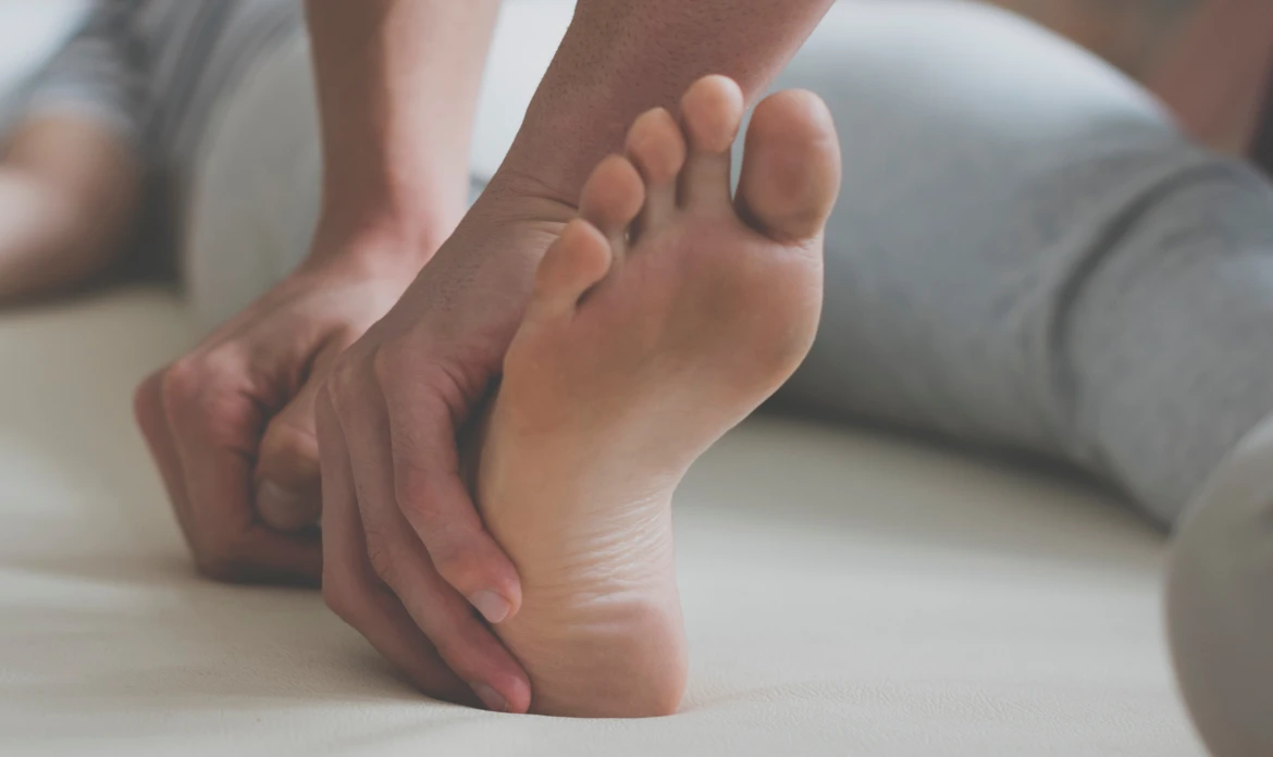 foot-pain-treatment person holding his foot in pain